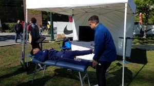 Athlete at Penn Relays getting treated by Dr. Booker 