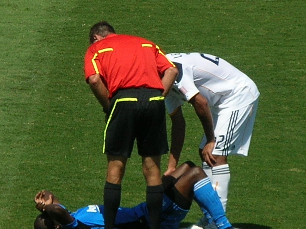 Soccer player lying injured on the field.